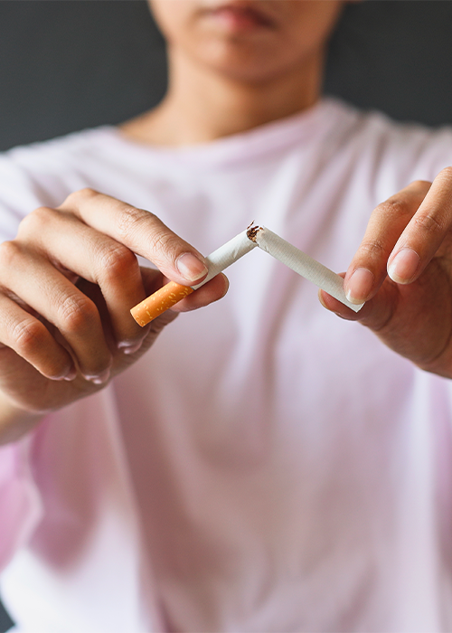 femme brisant une cigarette