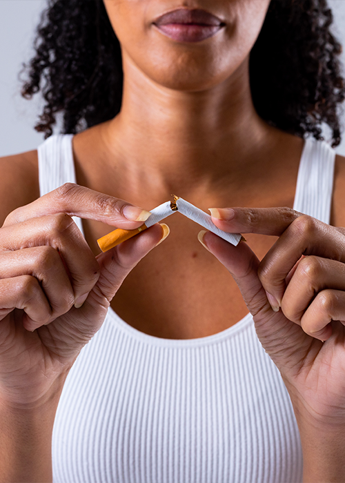 femme noire brisant une cigarette